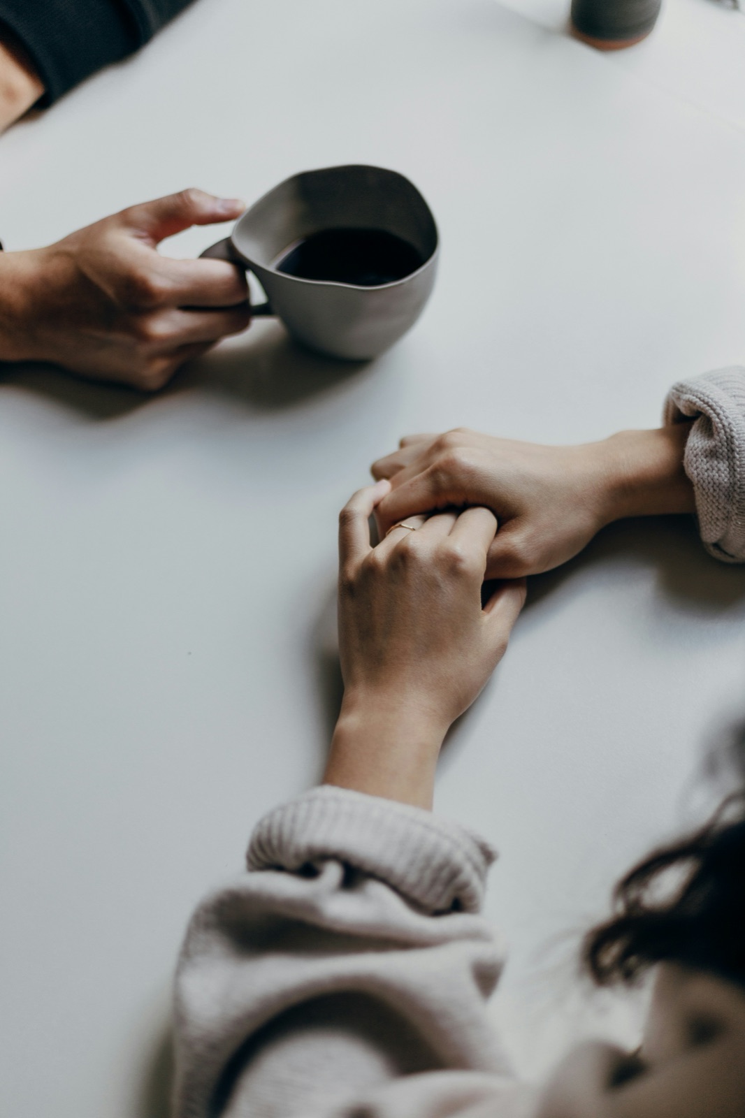 Two people in conversation across a table, over coffee