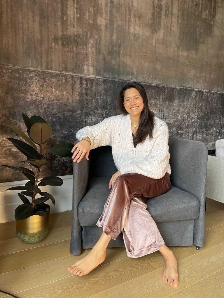 Portrait of Fay, smiling in a cream cardigan