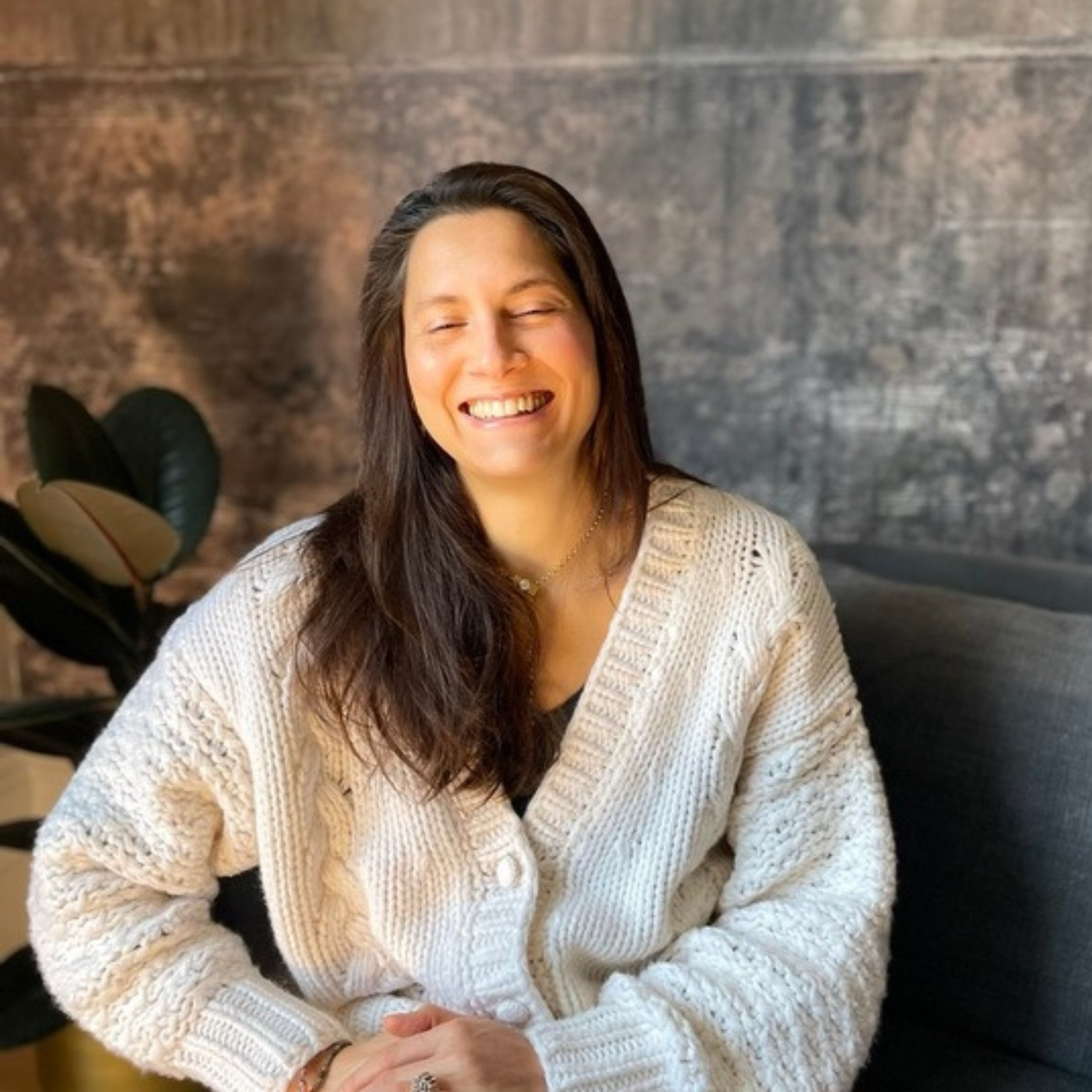 Fay laughing, in a cream cardigan