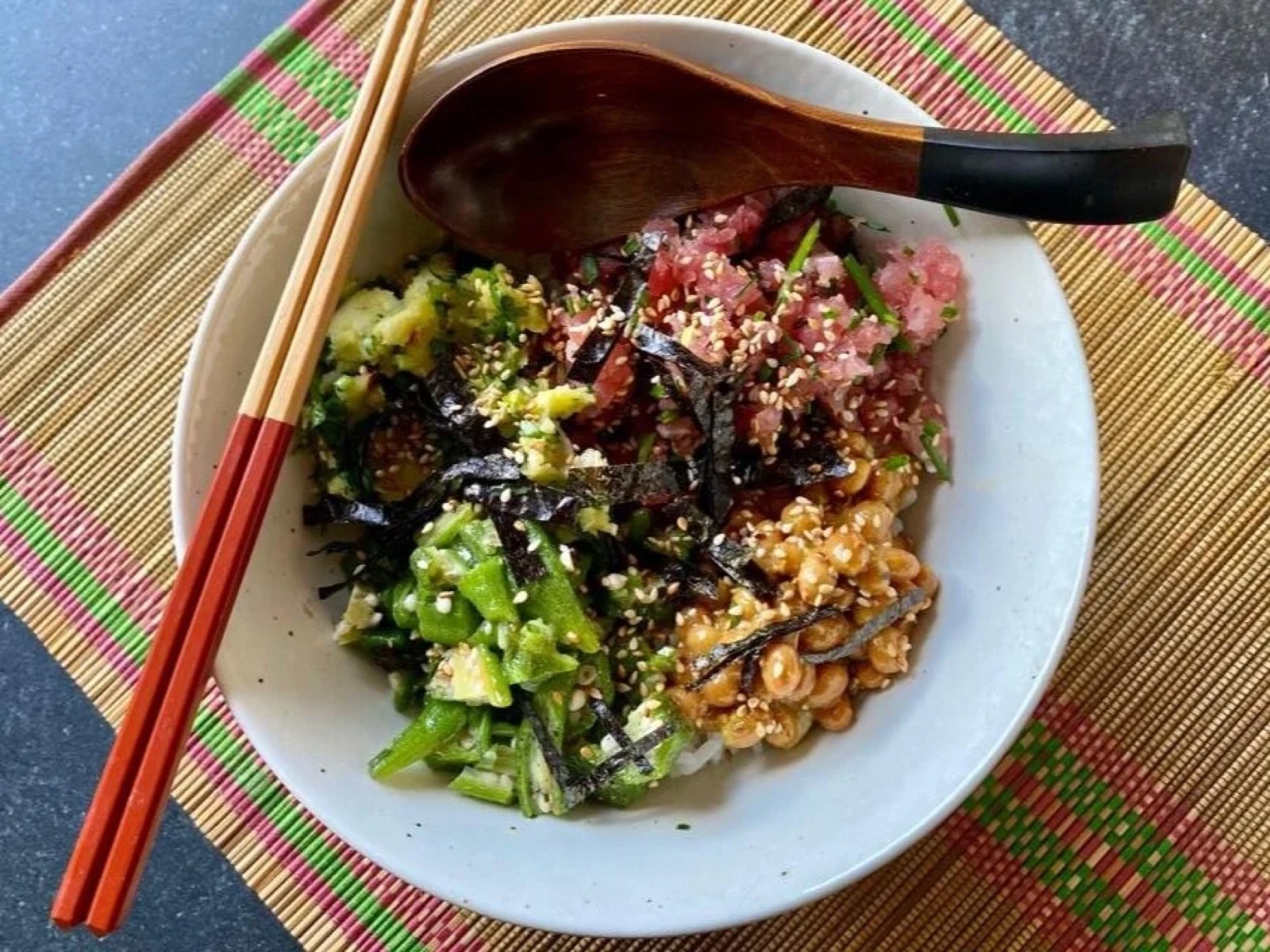 Gooey toro don in a bowl with chopsticks on a bamboo mat